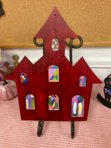 Wooden Church Craft project: Wooden Church Cutout painted red with stained glass paper windows.
